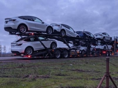 NexGen Auto Transport performing overland boat transport with a specialized tow rig moving a large sailboat across state highways.